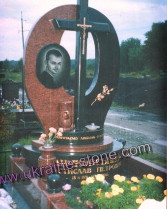 Пам'ятник із червоного граніту з хрестом в арці